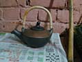 Unique style pottery, black and brown with cane handle kettle